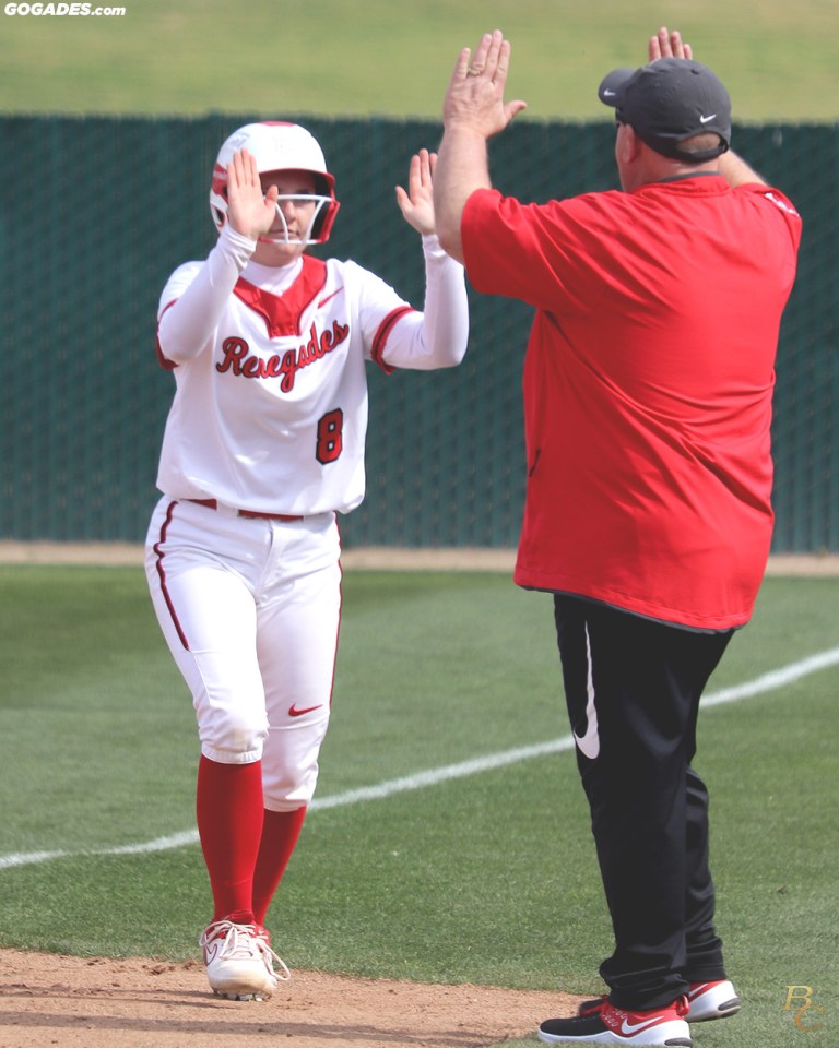 Softball player gives coach ten.